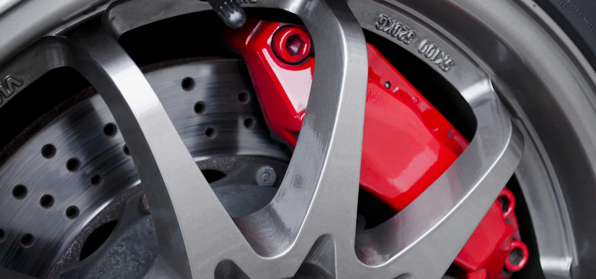 Close-up of car wheel with red brake caliper
