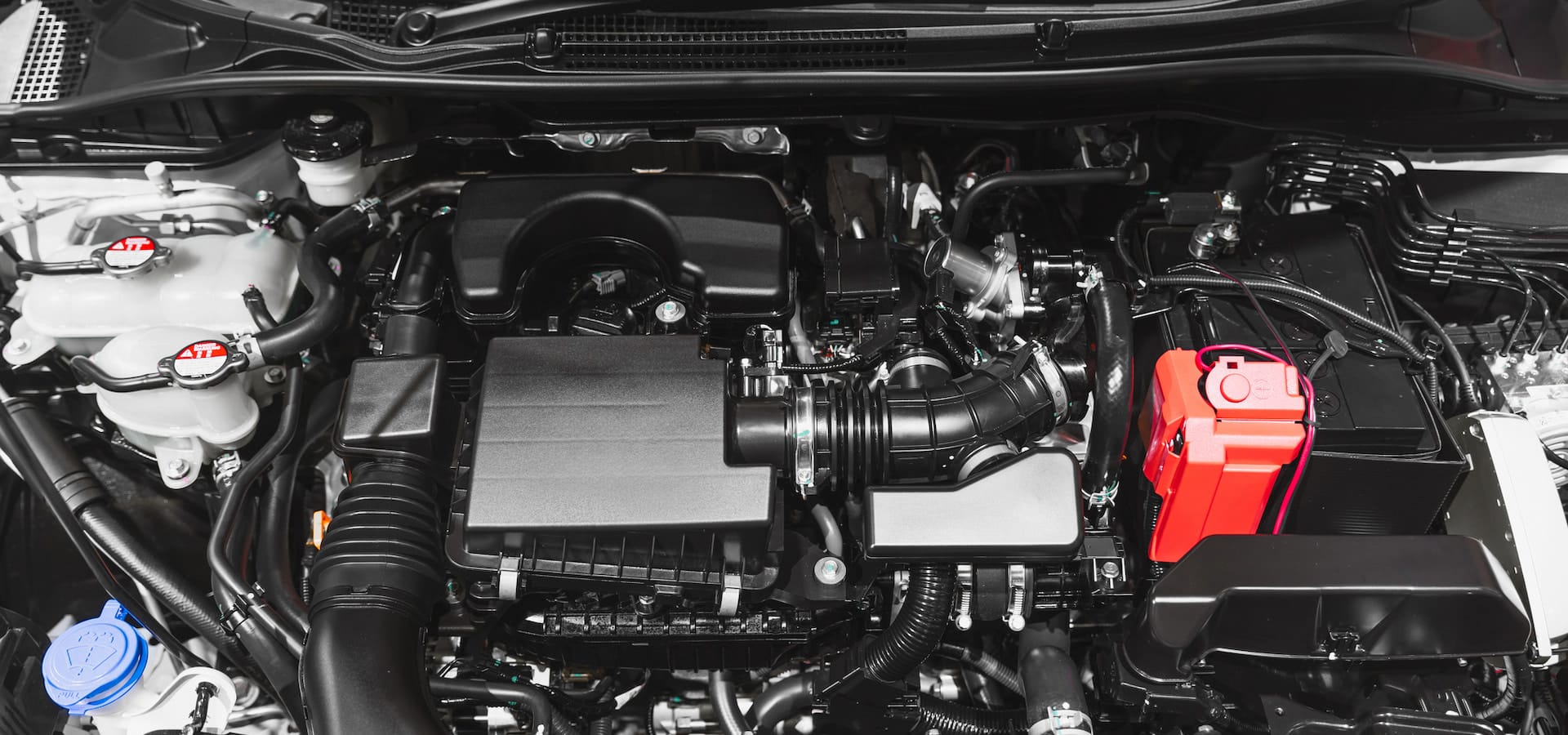 Modern car engine bay with battery and components