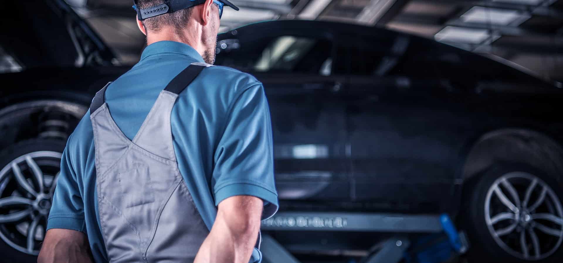 Auto mechanic inspecting car on lift