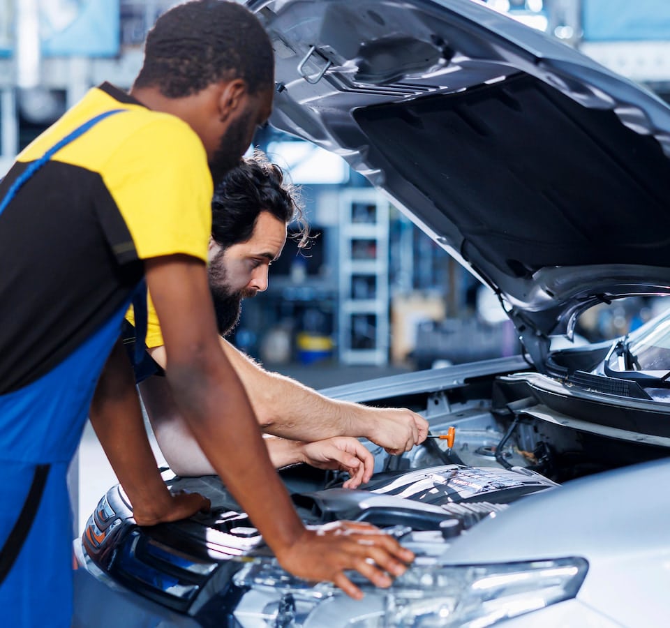 Auto Scheduled Service Maintenance Denver image Two mechanics inspecting car engine in auto shop