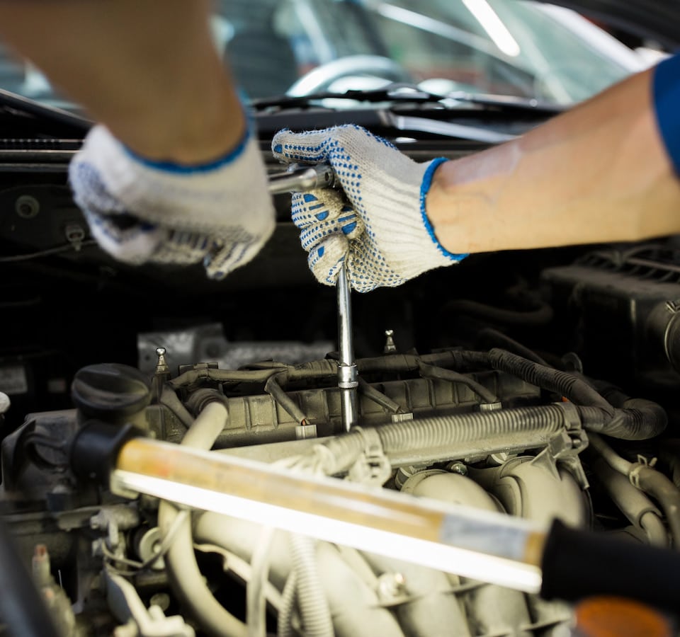 Auto Transmission Repair Denver image Mechanic tightening bolt inside car engine bay