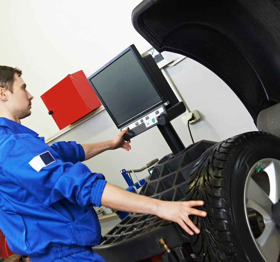 Auto Wheel Alignment Denver image Mechanic performing wheel alignment on car tire