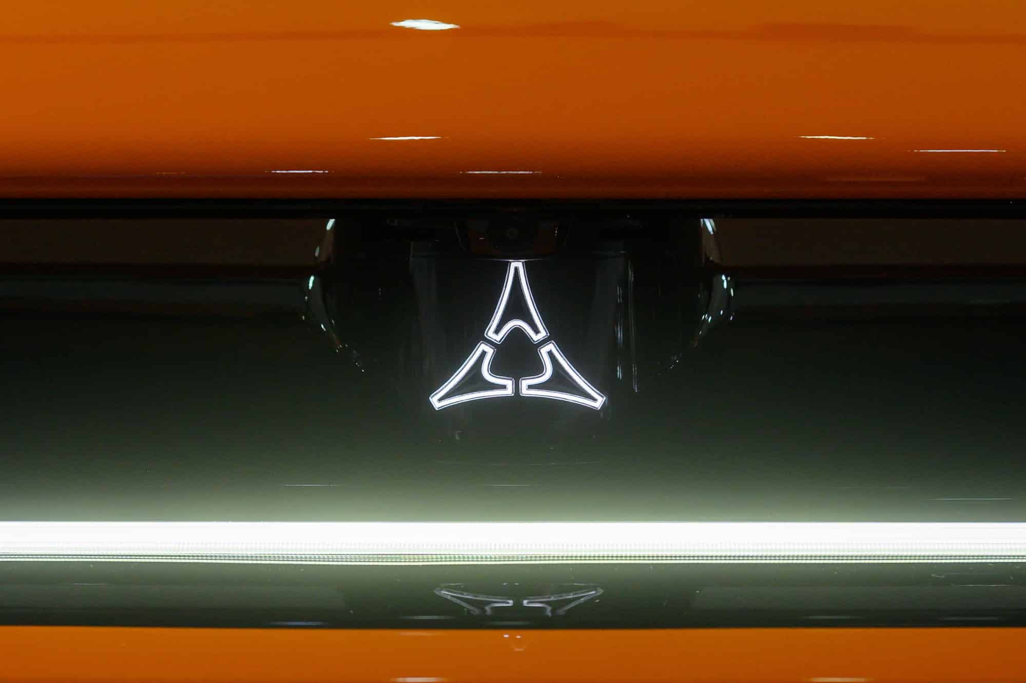 Illuminated triangular car emblem on orange hood