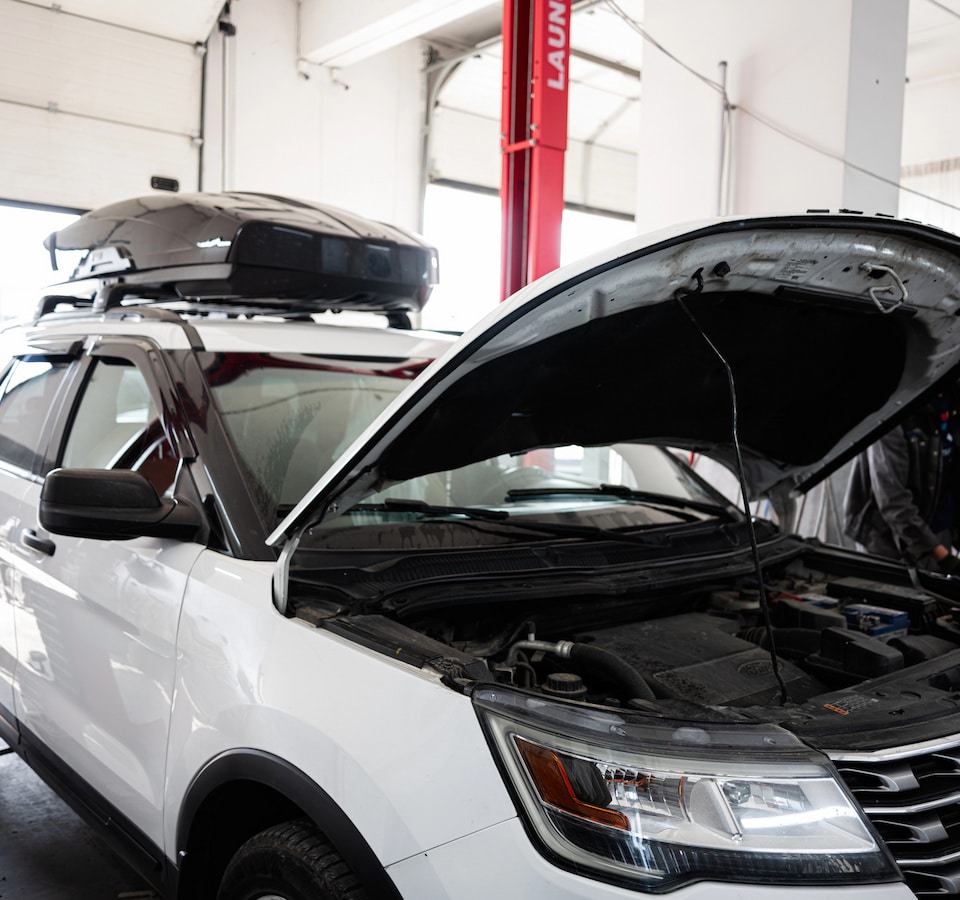 elevation-auto-repair-about-us-img White SUV with hood open in auto shop