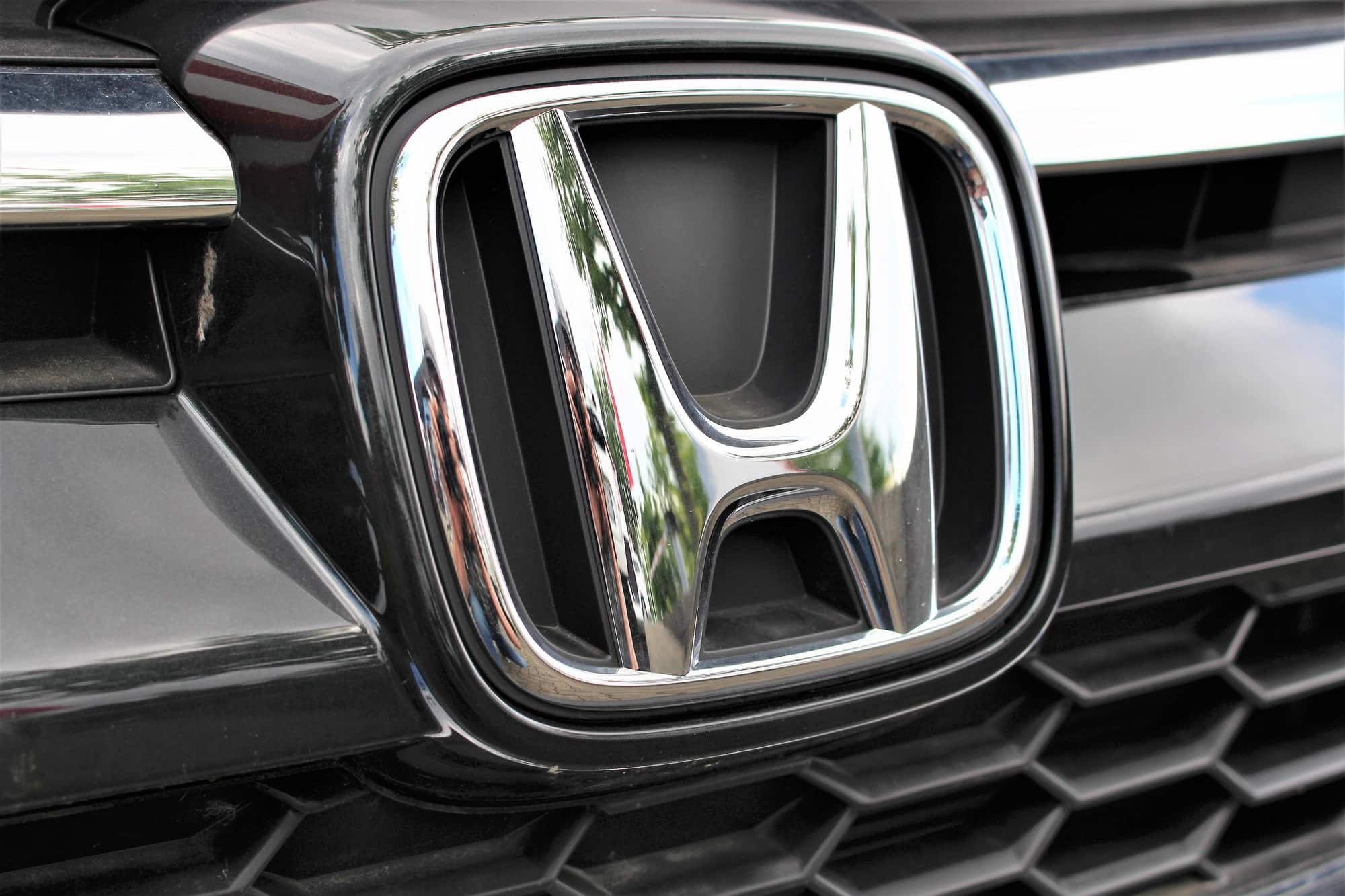 Close-up of Honda car emblem on grille
