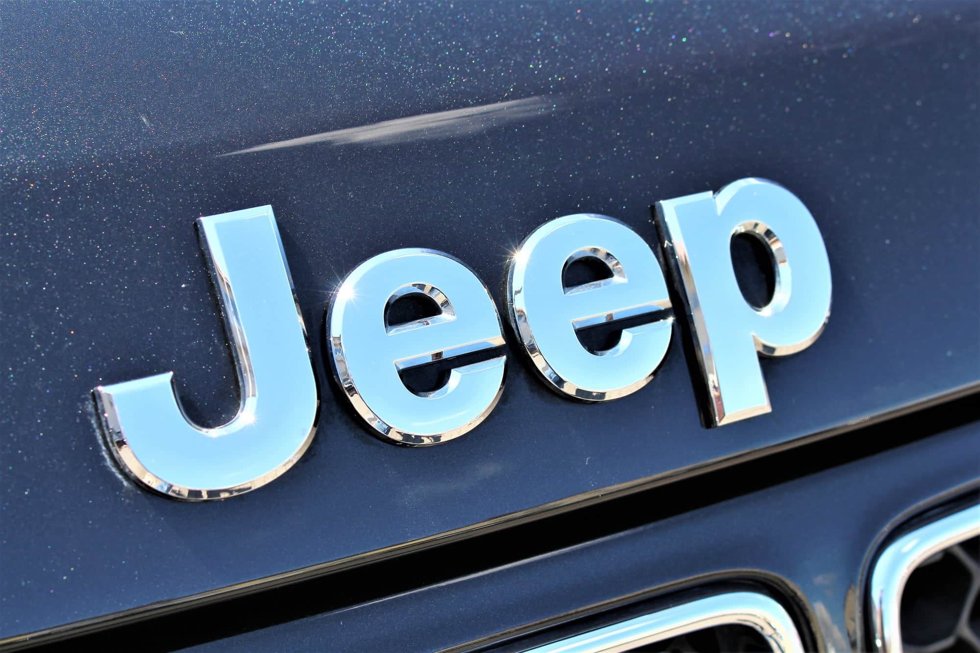 Chrome Jeep logo on blue vehicle grille