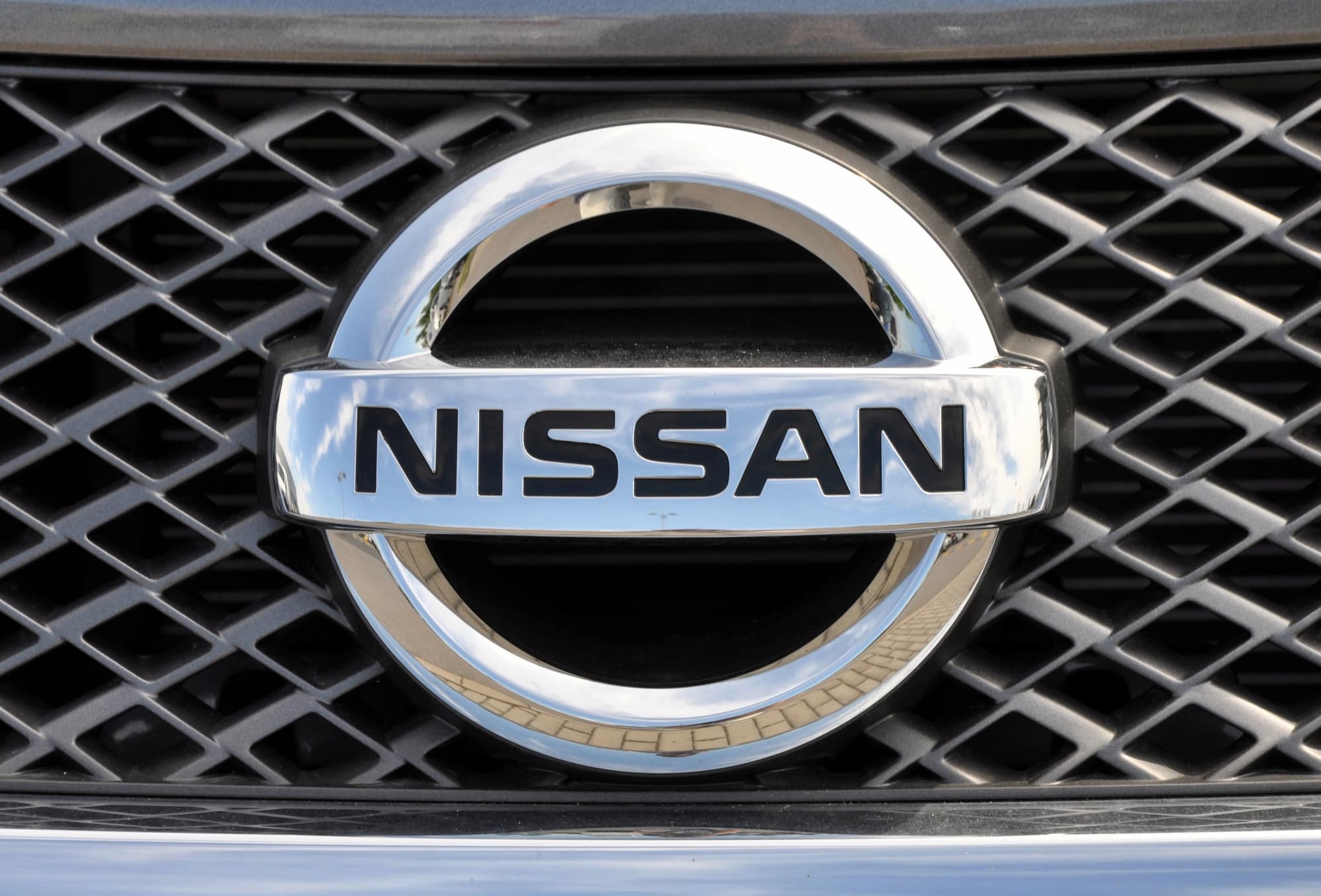 Close-up of Nissan logo on car grille